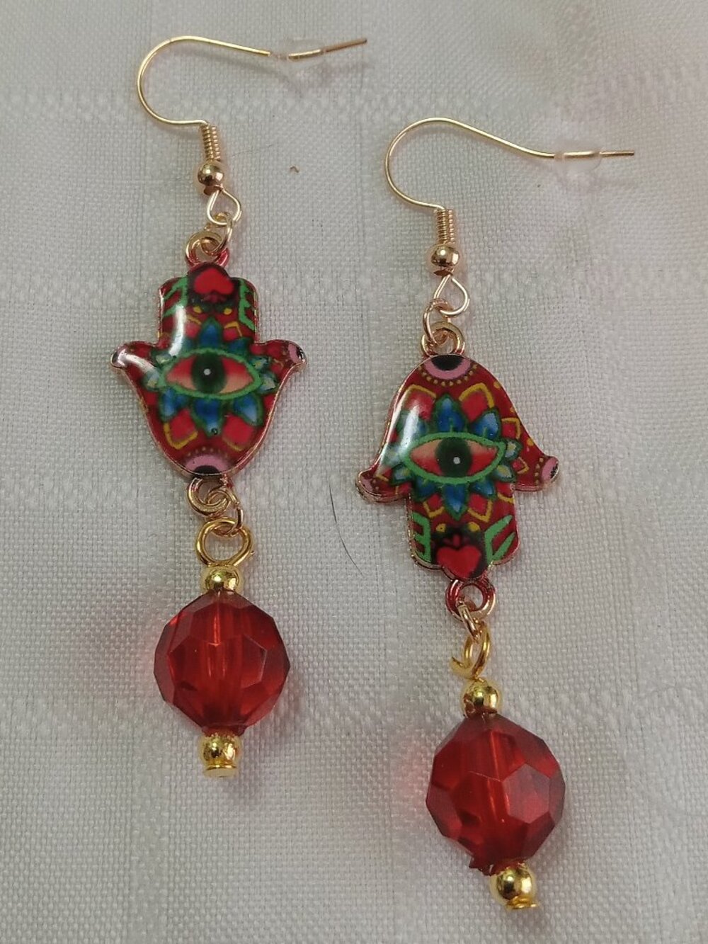 Handmade gold-colored earrings with multicolored enameled fatima hands and beads